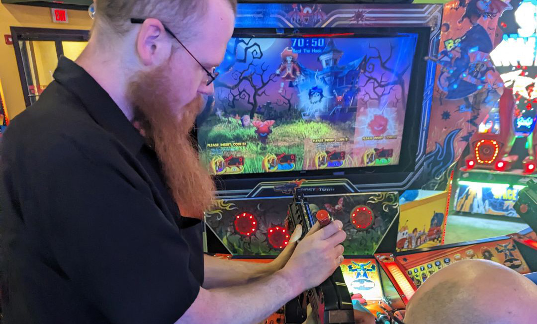 Guest playing a light-gun shooting arcade cabinet at Starrcade Kennesaw