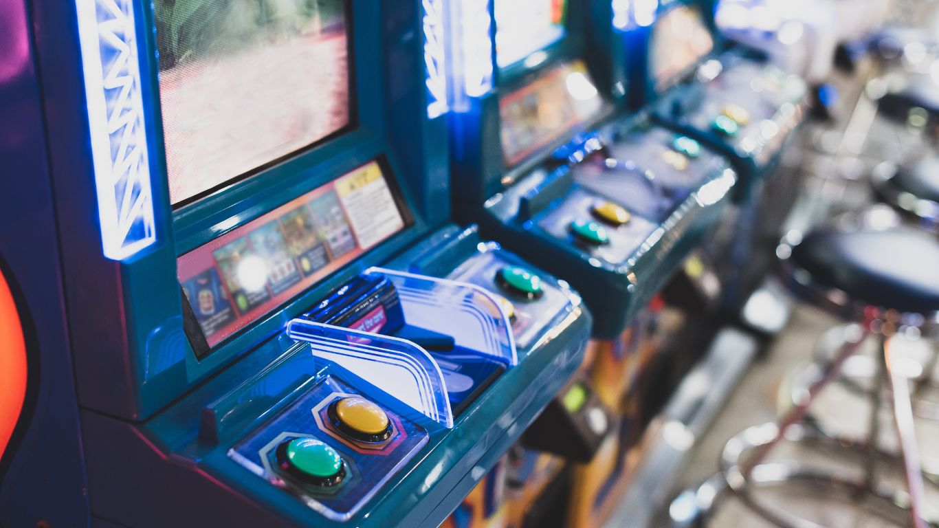 Row of arcade cabinets with lit buttons on the Starrcade Kennesaw floor