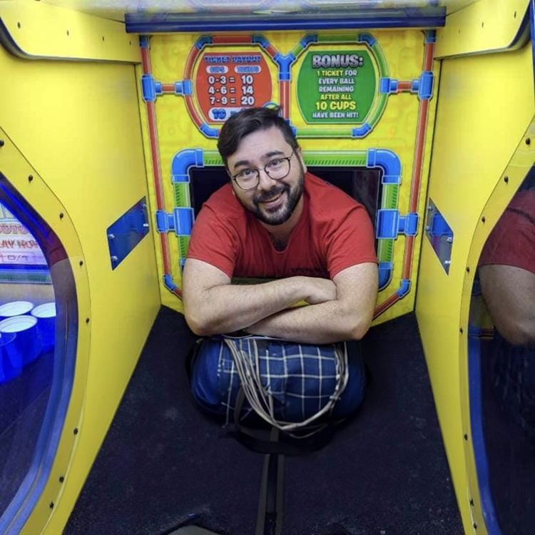 Starrcade Amusements technician inside a redemption arcade game